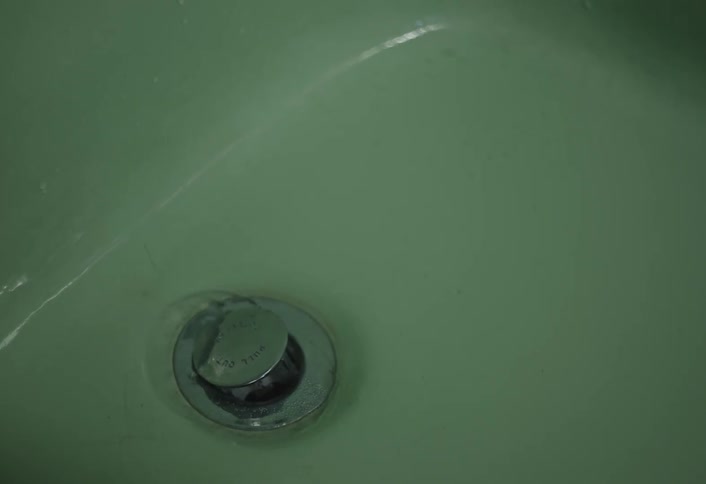 The water slowly enters the drain of the tub