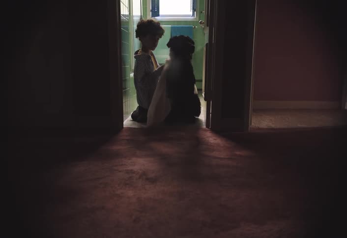 Boy kneels on the bathroom floor and dries his dog