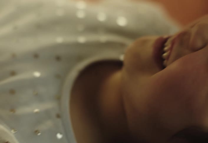 A close up slightly blurry view of a childs face with their mouth open as theyre laughing