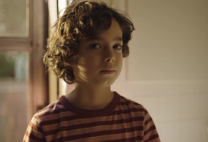 A boy is standing by the door