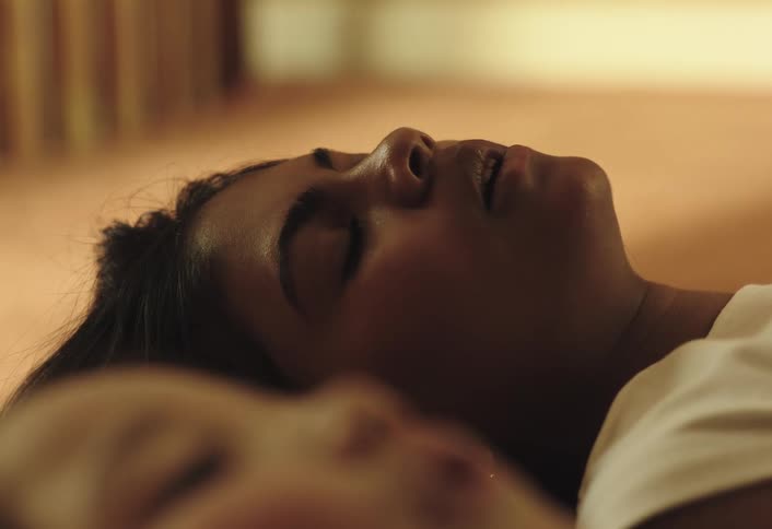 A mother and daughter fall backwards onto a bed in exhaustion and smile in relief