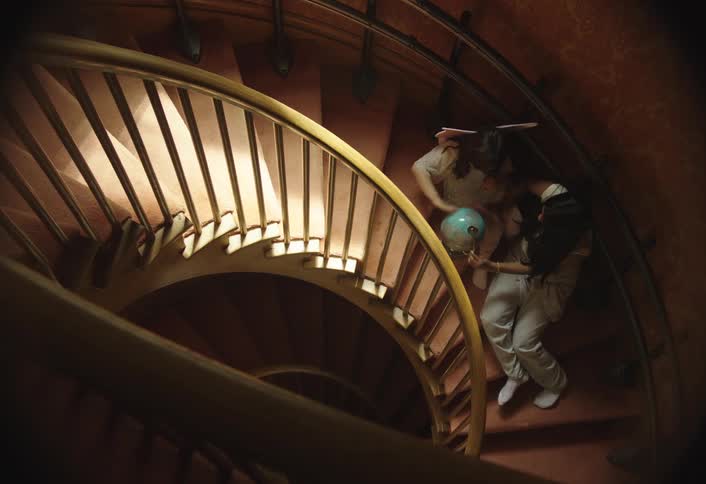 Two children sitting on the stairs and interacting with the globe