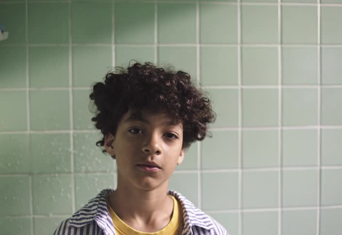 Boy in an indoor environment with tiled walls