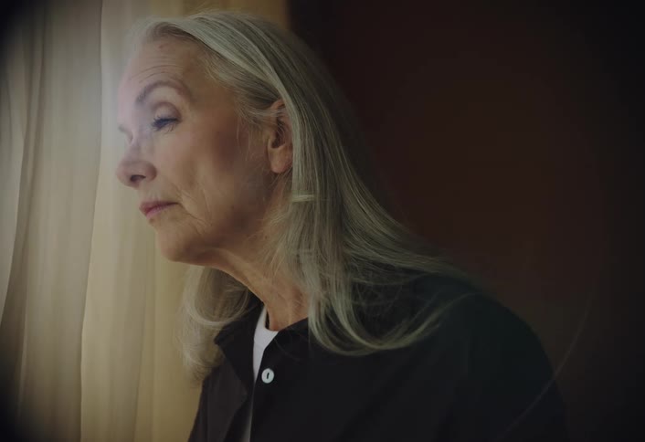 Elderly woman looking out of a window