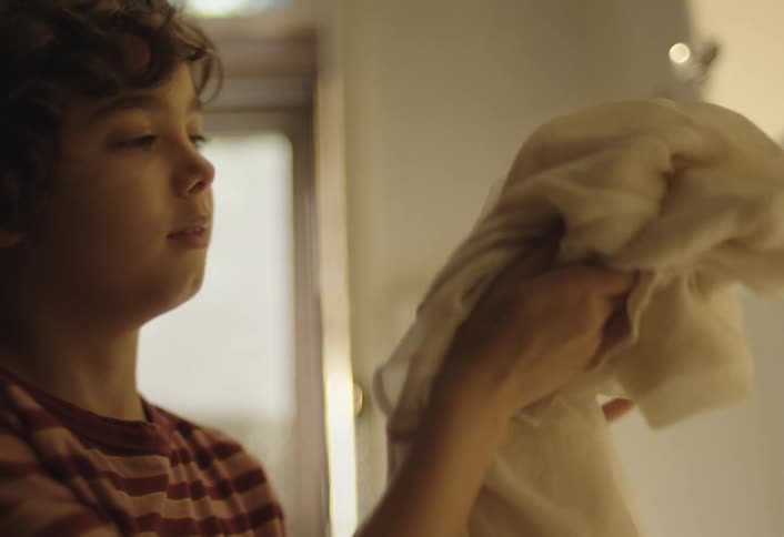 Boy smelling a piece of clothing