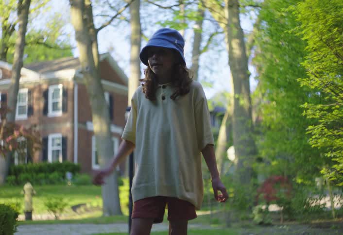 Young female teenager speaks while standing outdoors in suburban neighbourhood during daytime