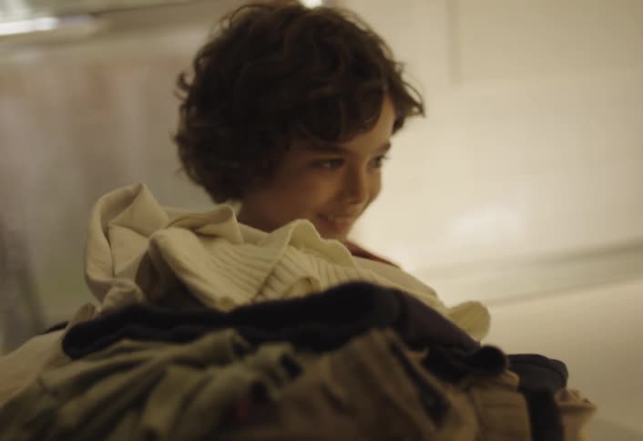 Boy taking clothes out of the washing machine