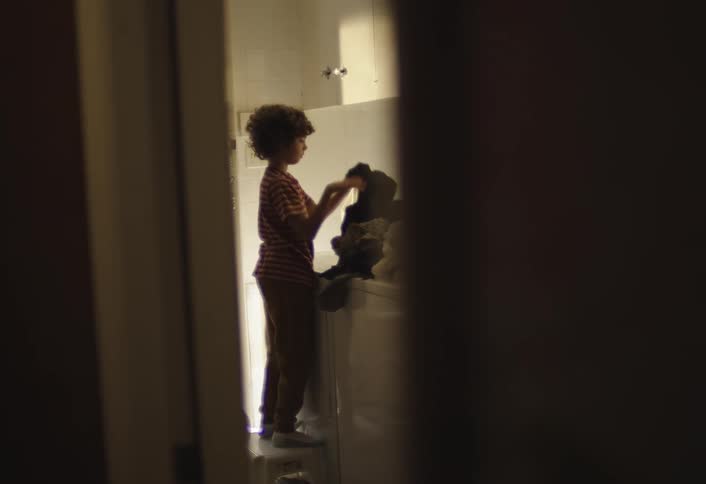 A child is removing clothing from the dryer