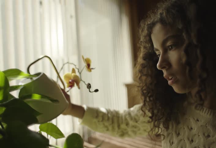 Girl with a teapot watering flowers and plants