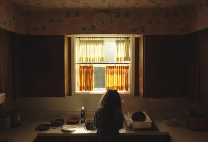 Child washing dishes during the day