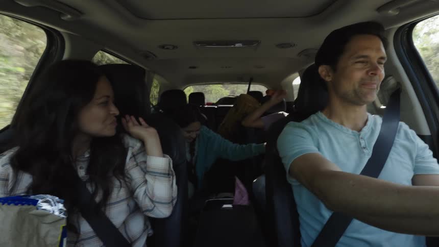 Family with two children having fun on a trip inside the car