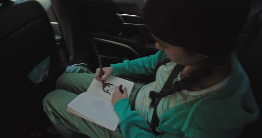 A family draw and play a game while on a road trip