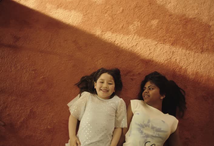 Two girls lying on the carpet smiling
