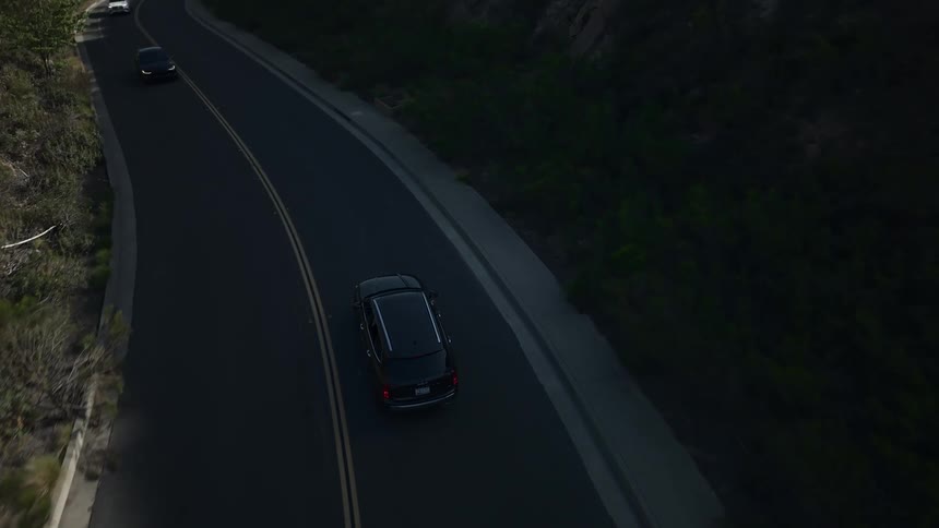 Black car traveling on a paved road