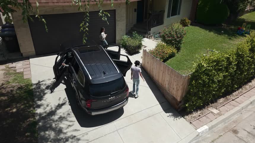 Family exiting a black suv parked in a homes driveway