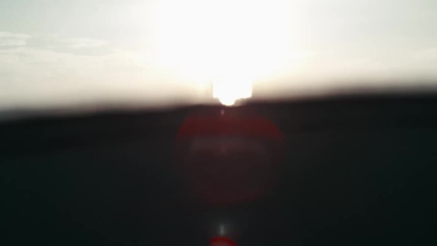Person standing in calm ocean water at sunrise