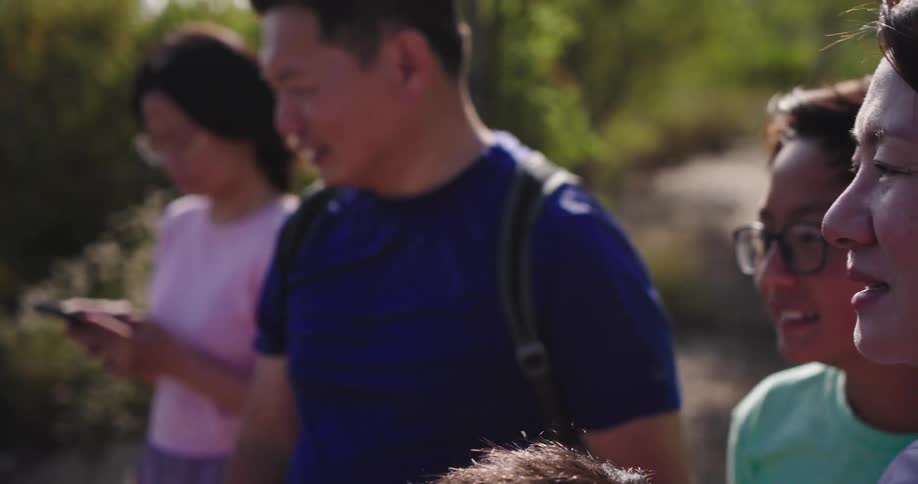 Members of a family out on a nature walk consult a smartphone