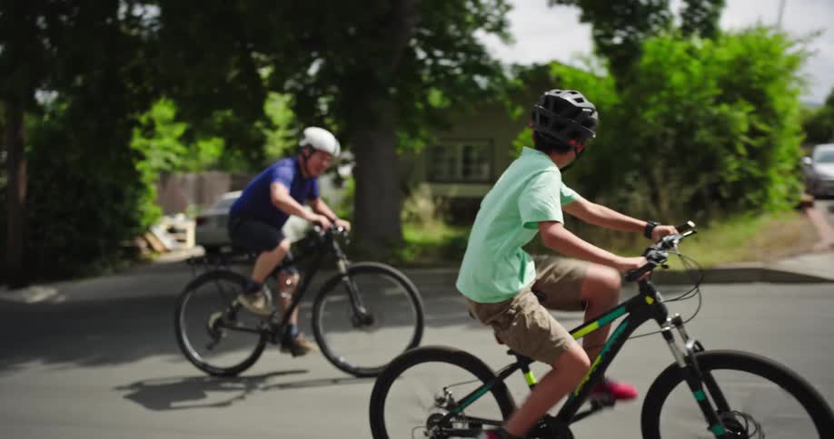 Father and son riding bikes through a suburb