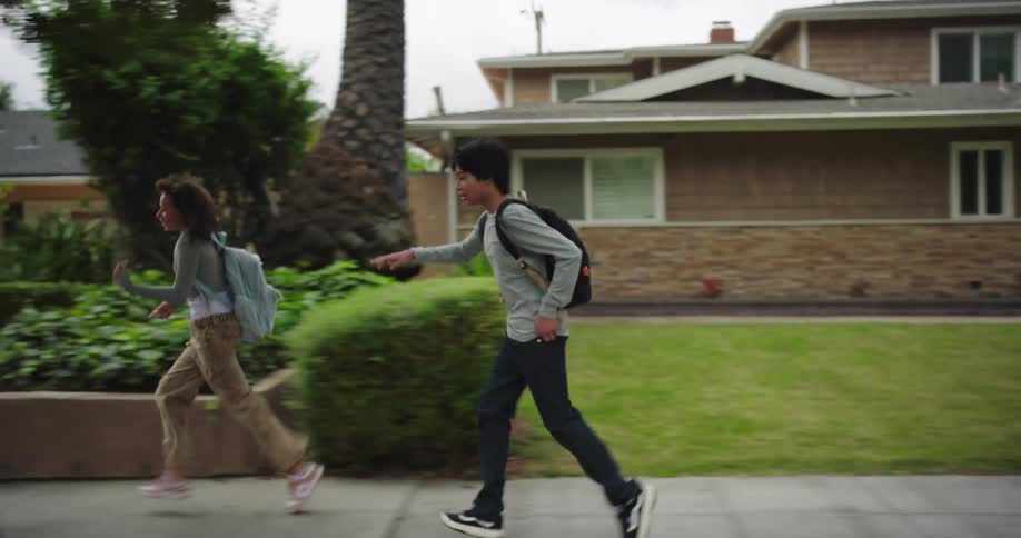 Two teenagers run past the homes