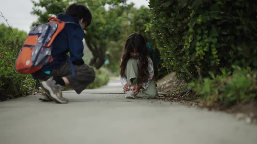 A girl ties her shoes then runs off