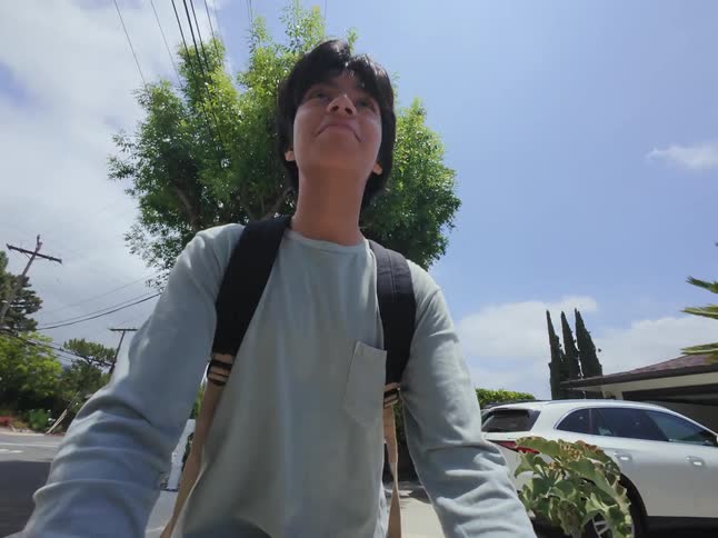 Portrait of a boy riding a scooter in a suburb