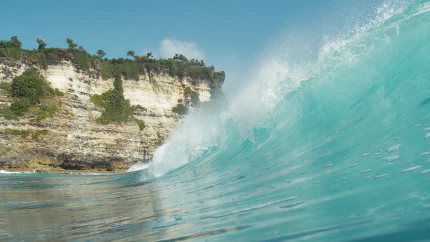 The blue wave heads towards the shore on a sunny day