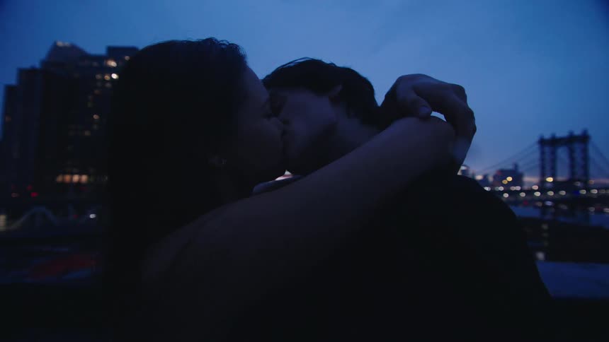 A couple hug and kiss on the roof top