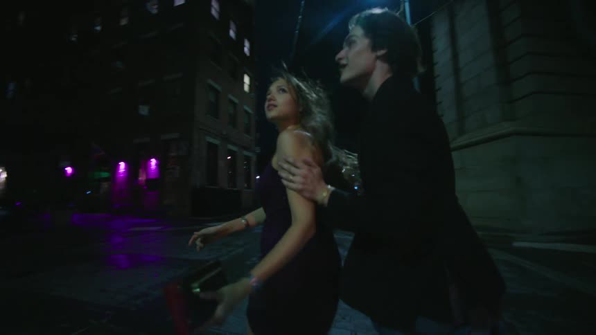 A man and woman run through the streets of a city