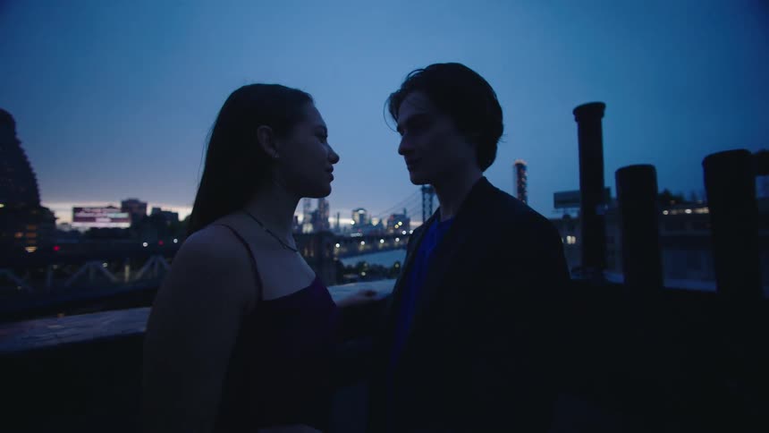 A couple are on the roof at sunset