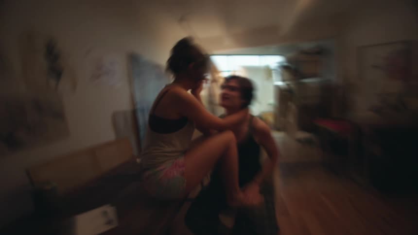 The video shows two individuals in what appears to be an intimate moment one person is sitting on a counter while the other stands closely in front of them engaging in an embrace or close interaction