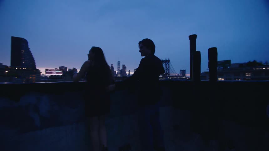 Happy couple enjoying the view of an urban city at dusk