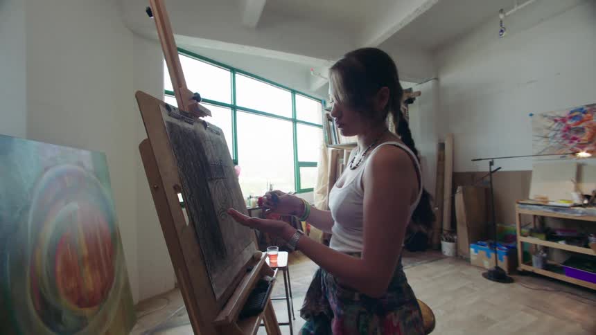 A woman paints in a studio