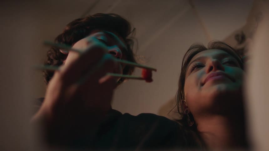 Couple eating with chopsticks and playing happily with each other