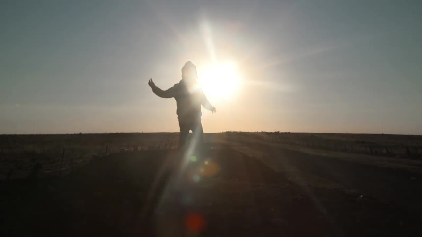 A person running towards the sun