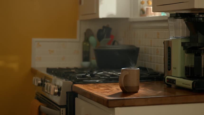 Person picking up a mug and a book