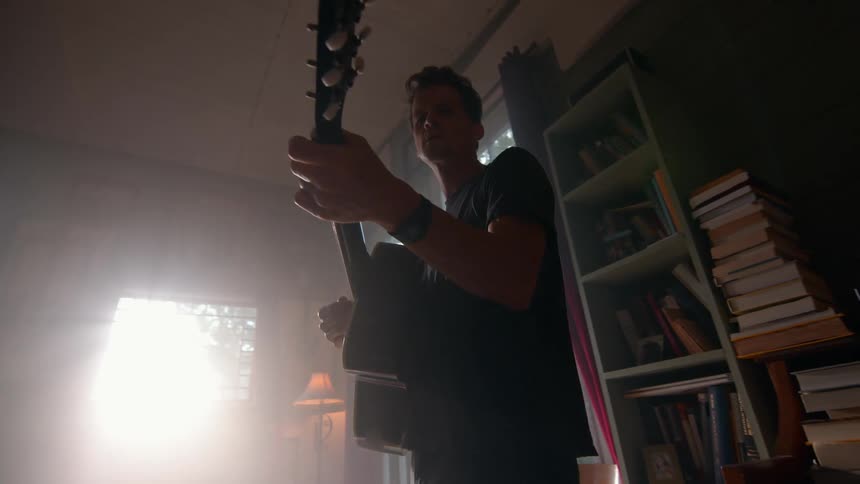 Man in the living room playing guitar