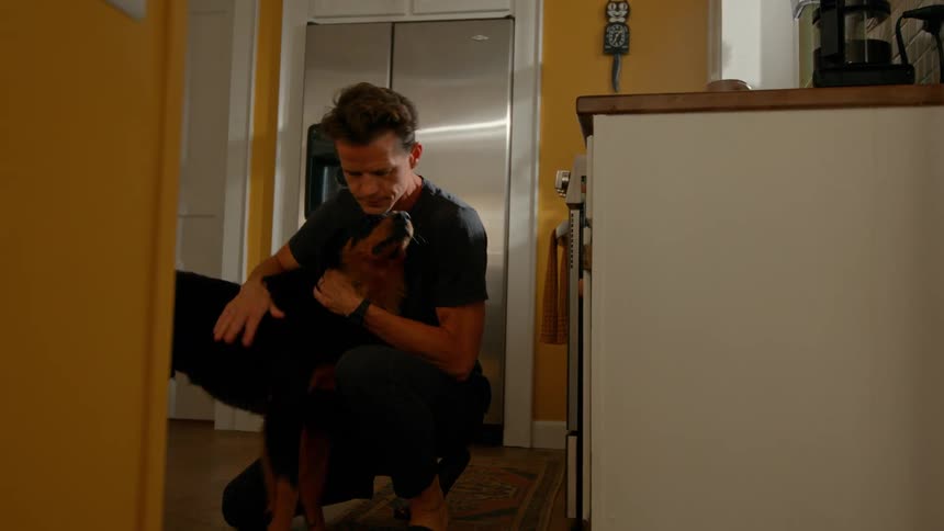 Man hugging and kissing his dog before they walk out the door together