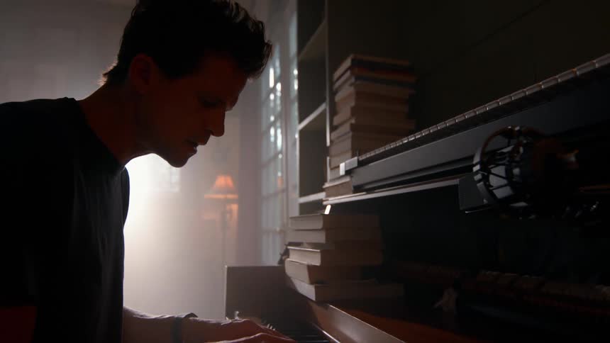 The man is playing the piano at home