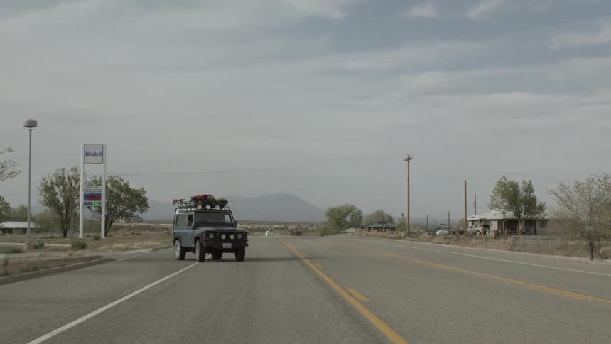 A jeep turns onto a rural road