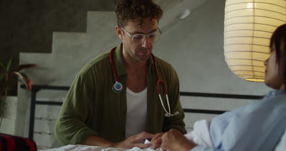 Healthcare professional picking up medical equipment and attending to a lying patient