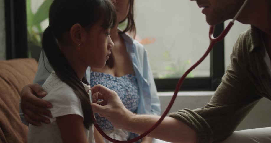 The doctor uses the stethoscope on the child