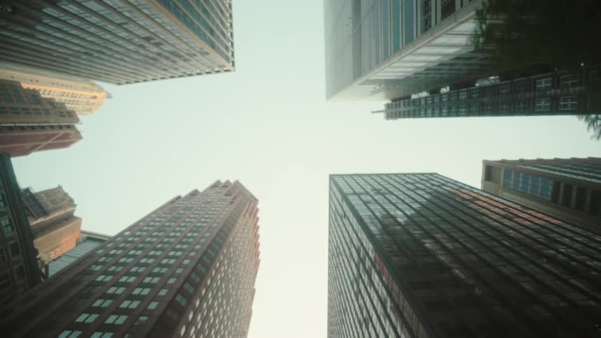 A tower block in a city is shown from the bottom up pointing at the sky