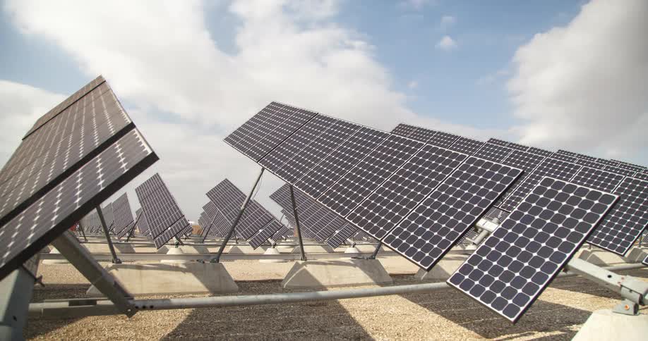 Several solar panels in an outdoor environment with blue sky and clouds passing quickly