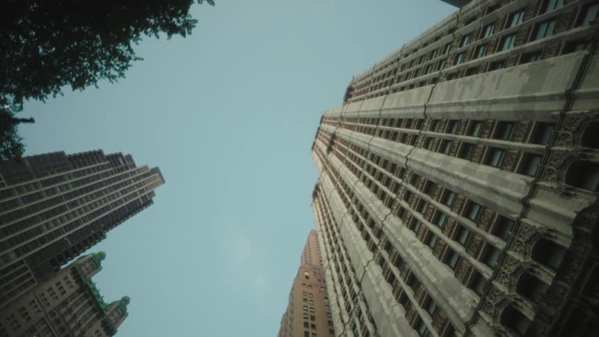 Upward view of large urban buildings against a blue sky