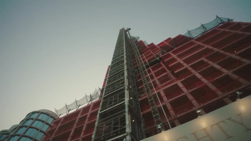 High rise under construction with cranes in city