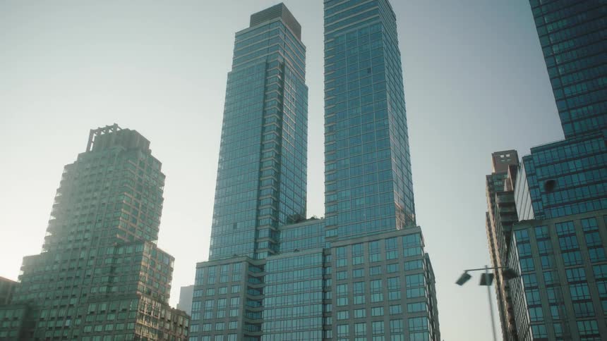 Tall modern skyscrapers stand closely together under a clear sky in a cityscape