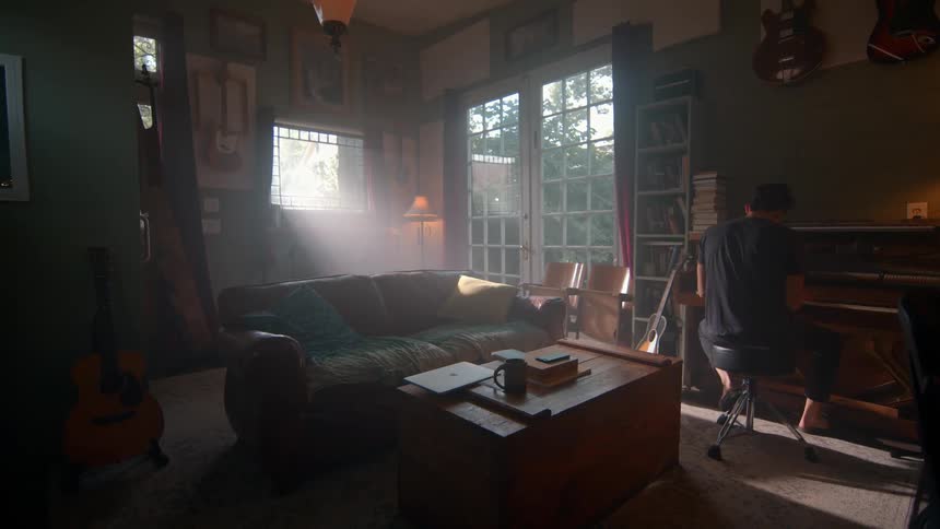 A young man drops his laptop and moves to play a piano in a living room during daytime