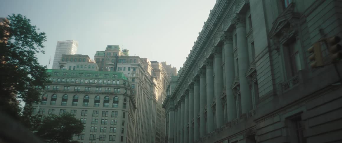 A cityscape shows tall historic buildings with ornate facades lining a narrow street
