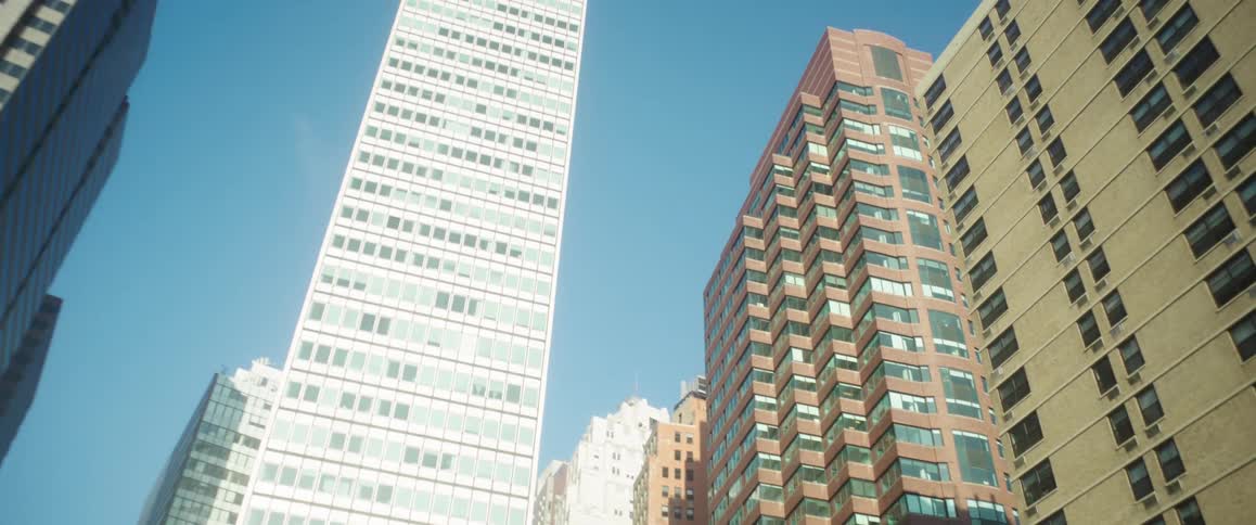 Several office buildings in a city center on a blue sky day