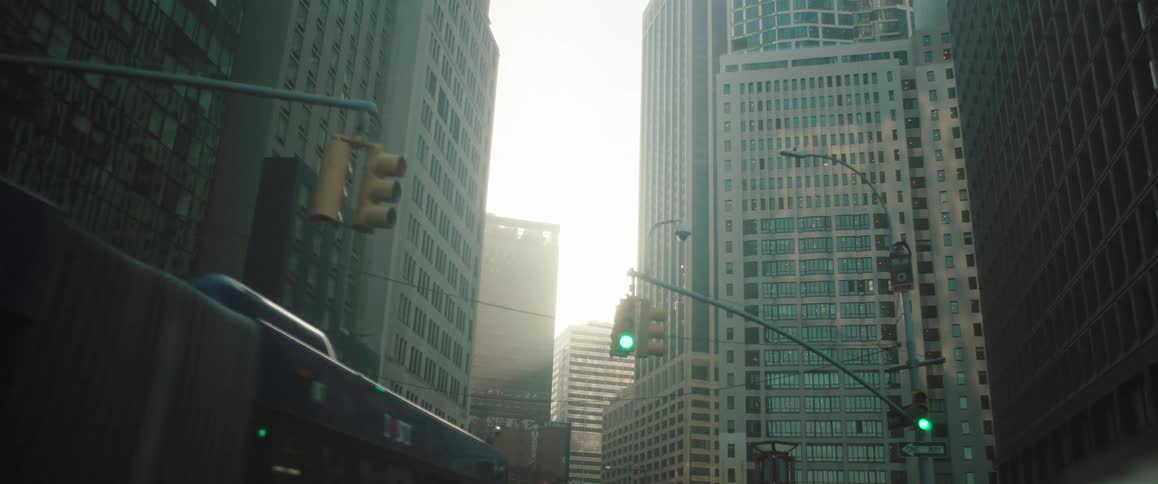 Sunlight streams through tall city buildings casting shadows across a narrow street below